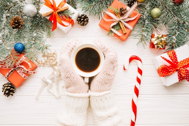 Рождественская композиция с перчатками, касающимися чашки кофе