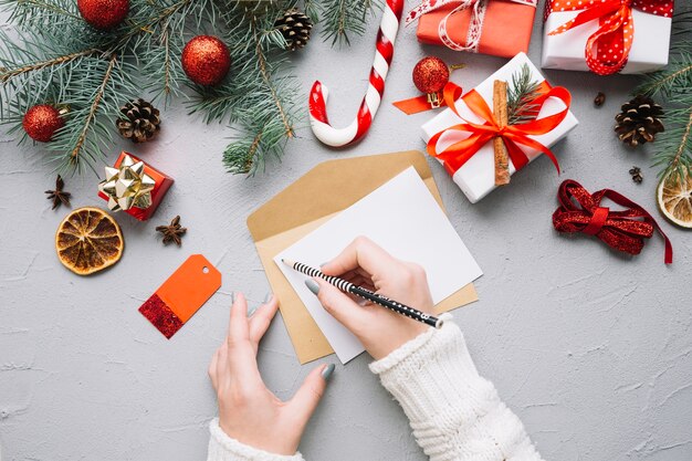 Christmas composition with hands writing letter
