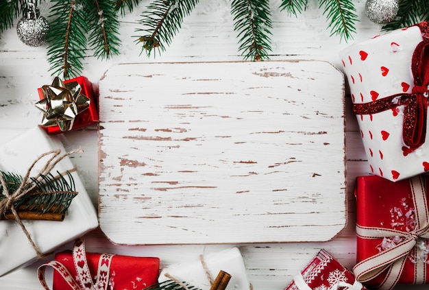 Free photo christmas composition of wooden board with gift boxes