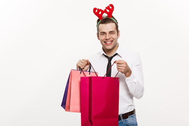 Рождественская концепция Красивый деловой человек празднует счастливого Рождества и счастливого нового года, носит ленту с оленем и держит большую красную сумку Санты