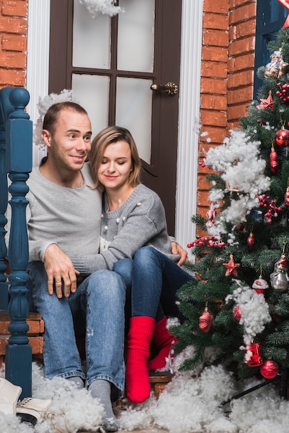 Free photo christmas concept with couple sitting outside