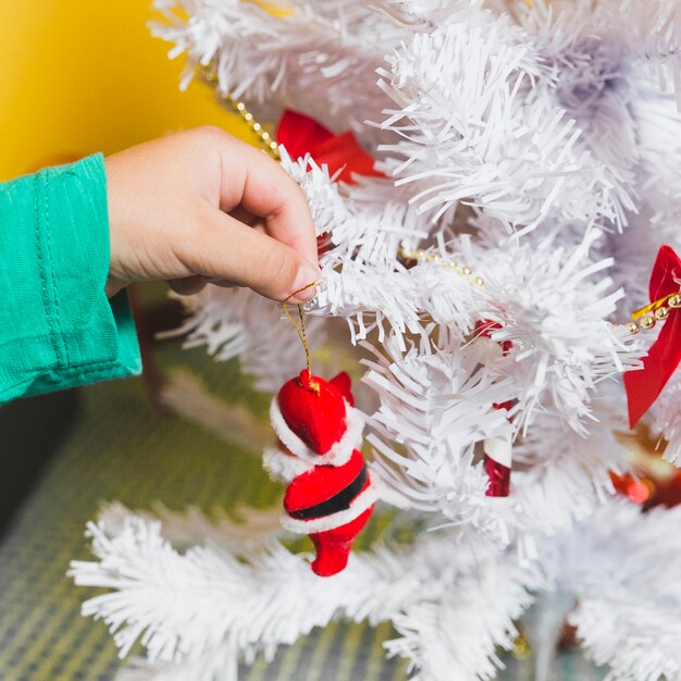 木を飾る手でクリスマスのコンセプト