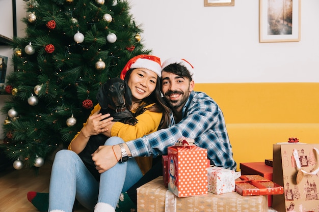 幸せなカップルと犬とクリスマスの概念