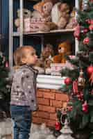 Free photo christmas concept with kid looking at christmas tree