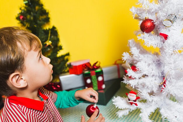 Christmas concept with kid looking at christmas tree