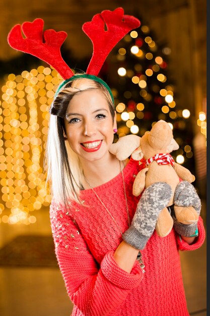 おもちゃのトナカイを持っている女性とクリスマスのコンセプト