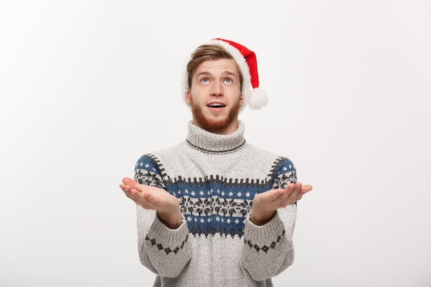 Christmas concept young cool beard man in sweater with waiting for snow gesture