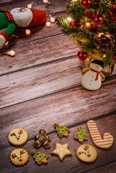 クリスマスのクッキーと木製の背景にライトとクリスマスツリー