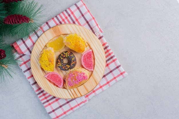 暗いプレート上のクリスマスクッキー、ドーナツ、マーマレード。