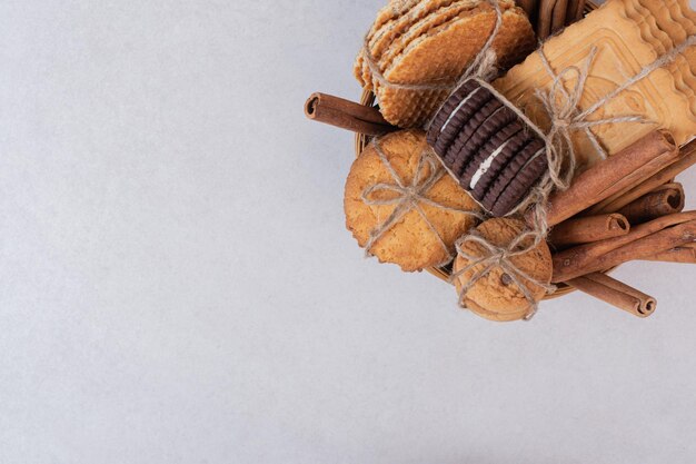 Christmas cookies with cinnamon in rope on white table.