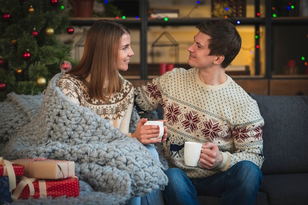 Christmas couple holding hot drinks