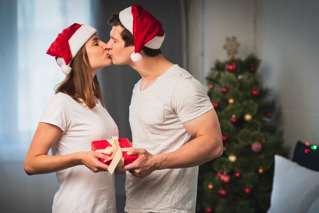 クリスマスのカップルが寝室でキス