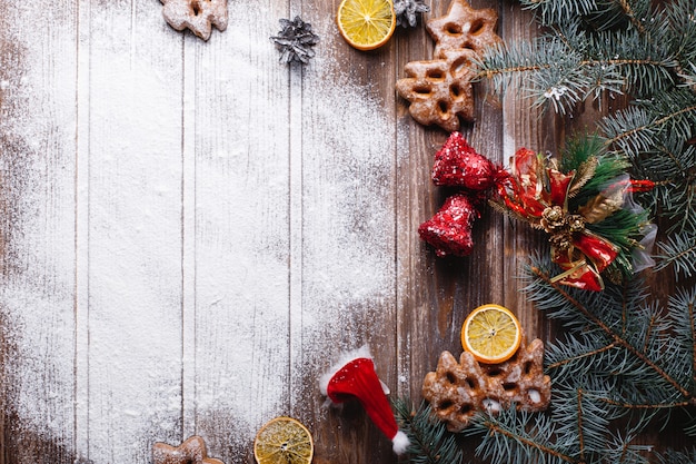 Christmas decor and place for text. White snow lies on a table surrounded with cookies