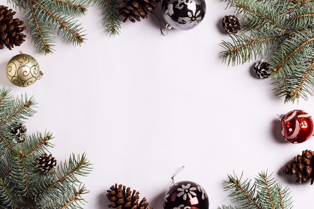 Christmas decoration composition pine cones balls spruce branches on white festive table