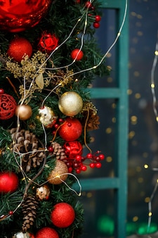 아늑한 집의 창문에 있는 전나무 가지와 장난감으로 만든 크리스마스 장식. 방에 있는 크리스마스 장난감