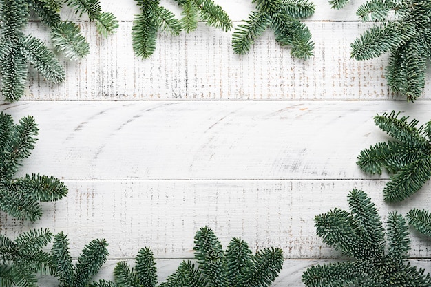 크리스마스 장식. 금색 싸구려, 원뿔, 종, 전나무 가지가 있는 휴일 장식 및 오래된 흰색 나무 보드 배경에 제공됩니다. 테두리 디자인입니다. 평면도. 조롱.