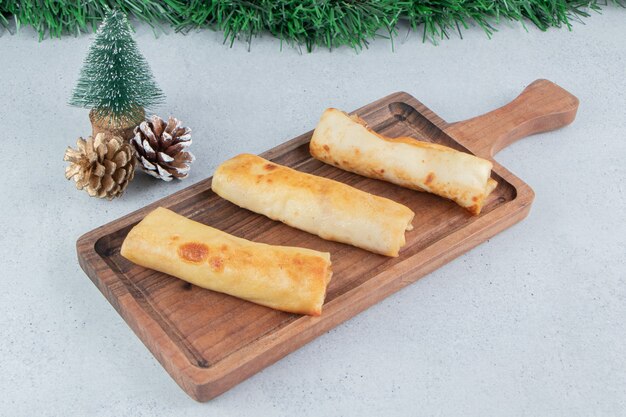 Christmas decorations and a tray of pancakes on marble background.