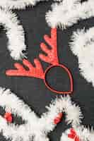 Free photo christmas deer horns with tinsel on table