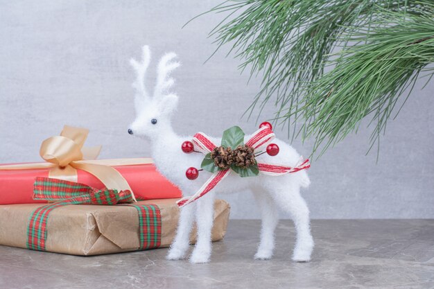 Christmas deer toy with festive gift box.