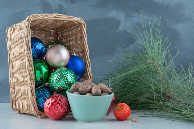 Рождественские праздничные шары с голубой тарелкой орехов. Фото высокого качества