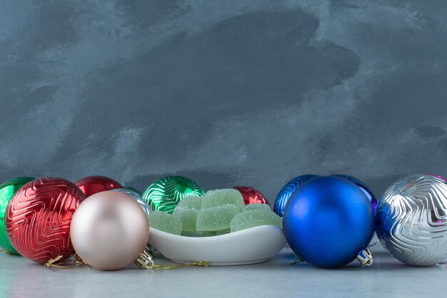 Christmas festive balls with white plate full of green marmalade . High quality photo