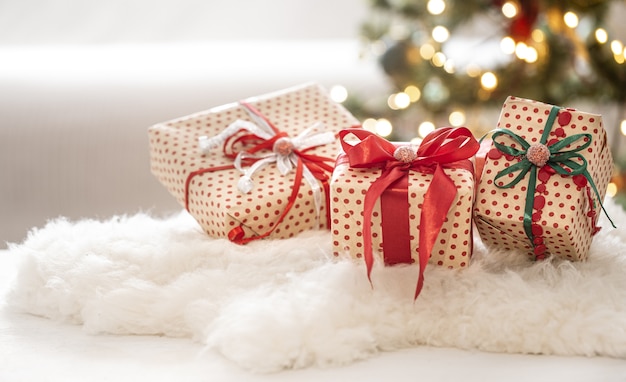 Free photo christmas festive composition with three gift boxes on bokeh background close up.