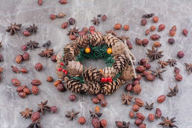 Christmas festive wreath with pinecones and star anise on marble background.