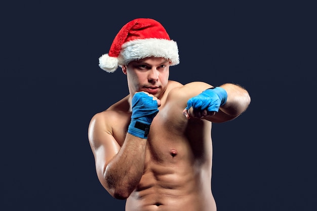 Christmas fitness boxer wearing santa hat boxing on black