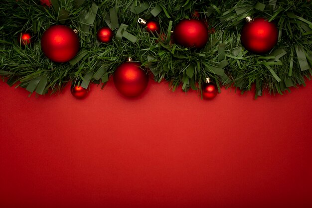 Christmas garland made of leaves and balls on a red table