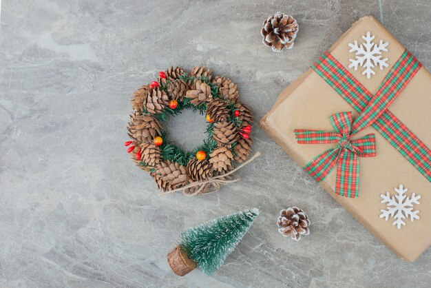 Christmas gift box, pine tree and wreath on marble.