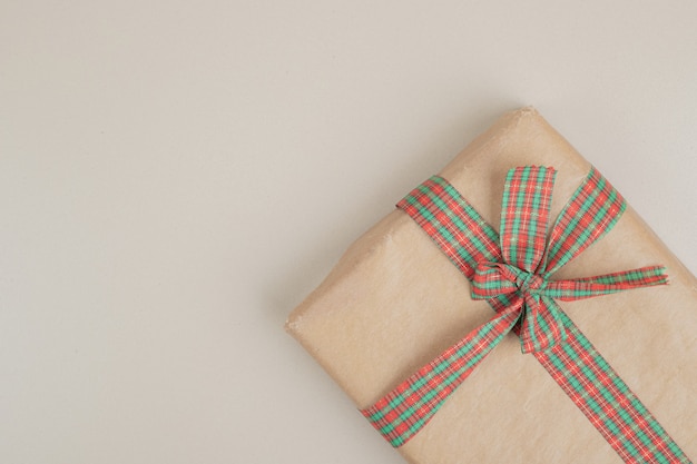 Christmas gift box wrapped in recycled paper with ribbon bow