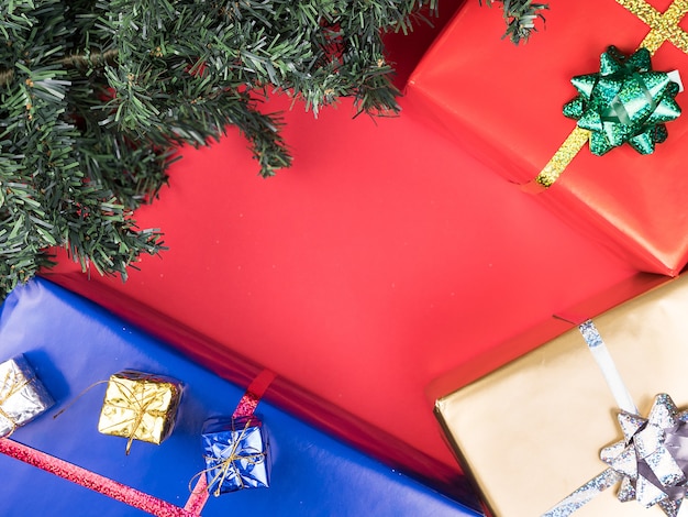 赤い背景の上のクリスマスギフトボックスとクリスマスツリー。伝統の飾り。