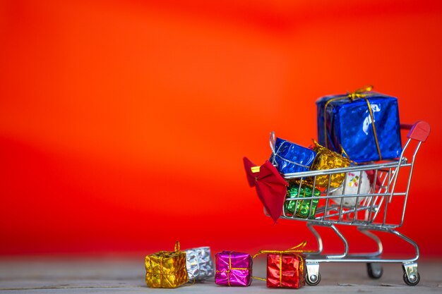 ショッピングカートに配置されたさまざまな色のクリスマスギフトボックス