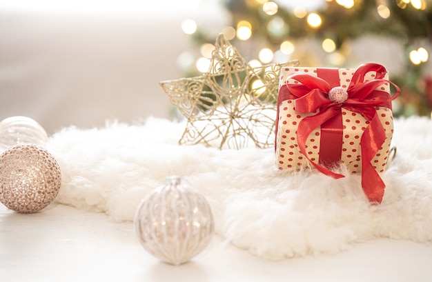 Рождественский подарок с украшениями на дереве на светлом размытом фоне копии пространства Боке.