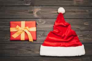 Free photo christmas gift with hat on wooden background