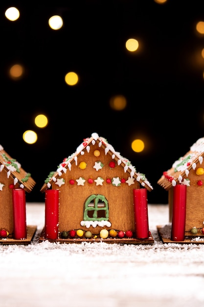 Christmas gingerbread house and Christmas lights on wooden table