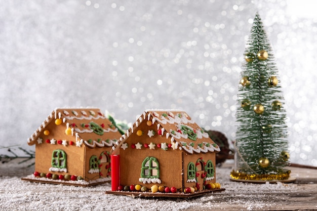 木製​の​テーブル​と​キラキラ​の​背景​に​クリスマスジンジャーブレッド​の​家