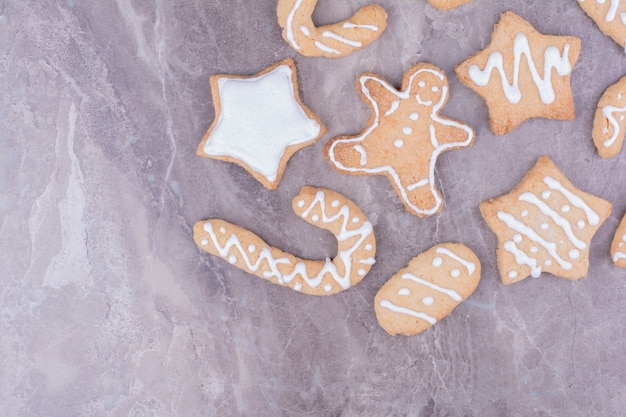 Christmas gingerbreads in different shapes on stone surface