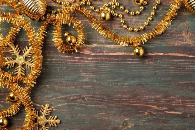テーブルウッドの背景にクリスマスゴールド安物の宝石と見掛け倒しの装飾飾り
