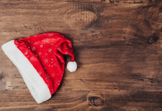 Бесплатное фото Рождественская шляпа на деревянной поверхности