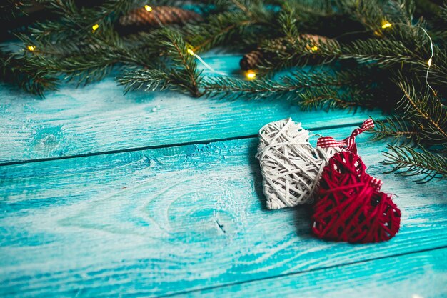 Christmas hearts on a blue wooden table with Christmas tree. Mock up.