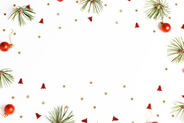 크리스마스 휴일 구성입니다. 축제의 창조적 인 빨간색 녹색 패턴, 소나무 가지, 크리스마스 빨간색 장식 휴일 공, 황금 색종이 조각, 별, 깃발, 흰색 배경에 눈송이. 평평한 평지, 평면도 프리미엄 사진