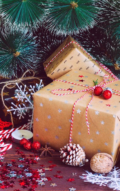 Christmas holiday gift box on decorated festive table with pine cones fir branches candy cane nuts