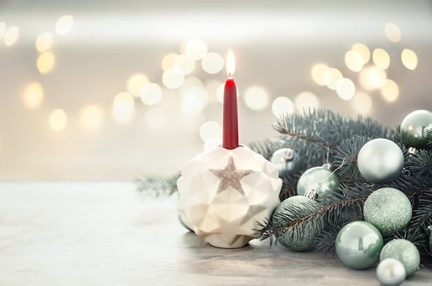 Christmas holiday wall with a candle in a candlestick.