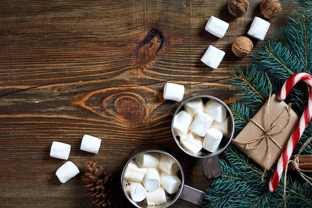 クリスマスの温かい飲み物。木製の背景にマシュマロ、チョコレート、トウヒの枝を持つココア。 2018年新年