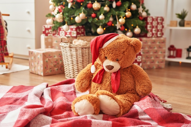 子供部屋​の​クリスマス​インテリア​保育園​の​クリスマス​。​クリスマスツリー​の​背景​に​柔らかい​おもちゃ​の​クマ