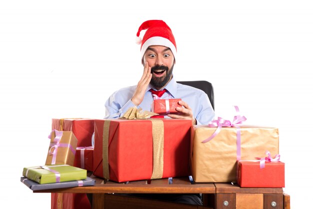 Christmas man in his office with several gifts