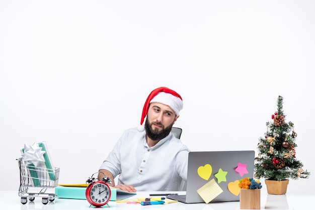 Christmas mood with confused young adult with santa claus hat checking his mails in the office