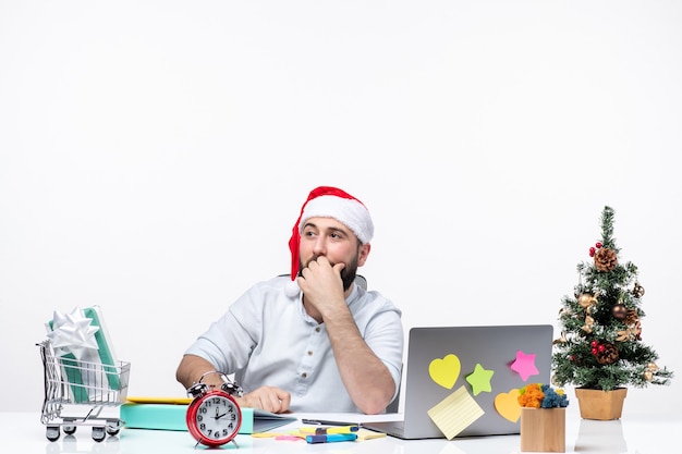 サンタクロースがオフィスでプロジェクトに従事している両手で上を指している若い大人とのクリスマス気分