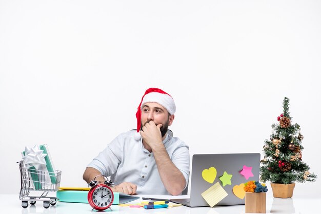 Atmosfera natalizia con un giovane adulto con il suo babbo natale che punta sopra con due mani impegnate in un progetto in ufficio